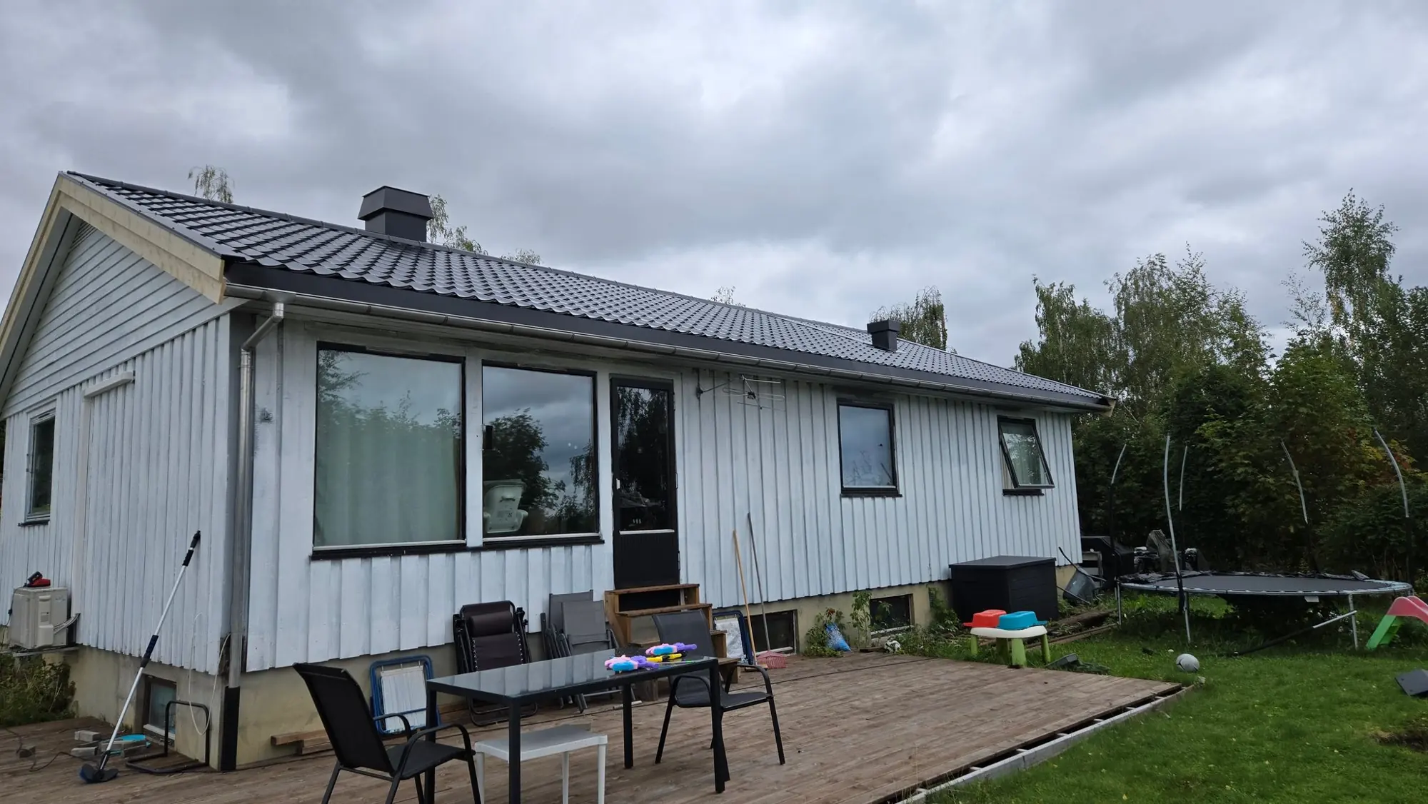 Enebolig med nytt svart tak, sett fra terrassen